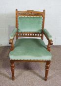 A late Victorian oak framed armchair, circa 1900, the crest rail carved with a bird and foliate