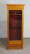 An oak gun display cabinet, early 20th century, with six gun stands, over a single drawer, 154cm