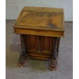 A Victorian walnut veneered Davenport, circa 1870, with a hinged sloping fall, two stationary boxes,