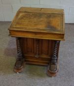 A Victorian walnut veneered Davenport, circa 1870, with a hinged sloping fall, two stationary boxes,
