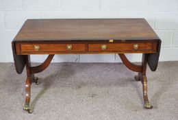 A Regency style mahogany and rosewood sofa table, 19th century, with a rounded drop leaf top,