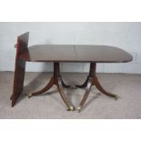 A George III style twin pillar mahogany extending dining table, circa 1900, with reeded top,