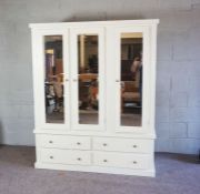 A large modern white painted wardrobe, fitted with hanging space, linen shelves and drawers, 150cm