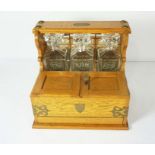 A Victorian style oak Tantalus, fitted with three cut crystal decanters, with hinged compartment,