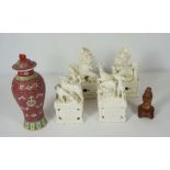 A pair of modern Chinese monochrome porcelain lions, on integral stands, 21cm high; together with