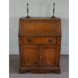 An early 20th century bureau, with carved sloping fall front; also included a pair of modern twist