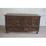 An oak panelled coffer, early 18th century, the hinged top over a fielded panelled front, with