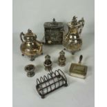 An assortment of assorted silver plated service ware, including a biscuit tin, toast rack, teapot