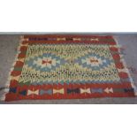 A small Kilim rug, with three lines of octagonal roundels on a light pink red ground, 176cm x 132cm