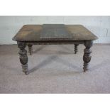 A late Victorian oak extending dining table, with carved border and set on cup and cover legs with