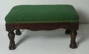 A small George III mahogany footstool, with green fabric top, the turned legs with hairy paw feet,