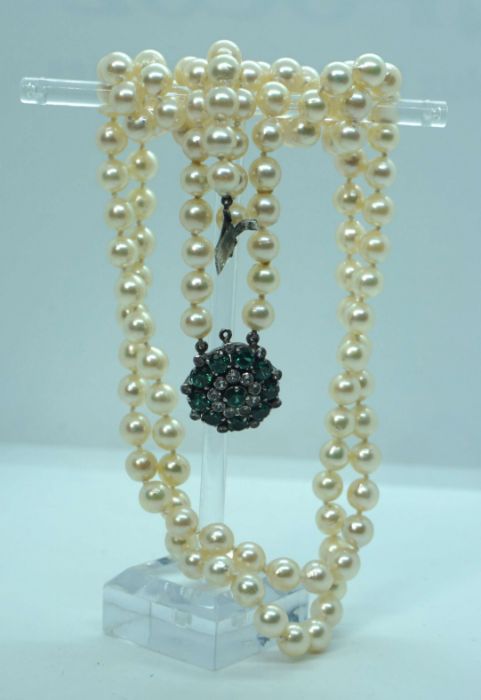 A Vintage cased necklace of cultured and graduated pearls, with a paste ‘emerald and diamond’