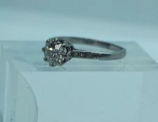 A diamond and platinum set engagement ring, the brilliant cut central diamond (approx 1.07