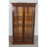 A modern mahogany china display cabinet, with two glazed panelled doors and glass shelves