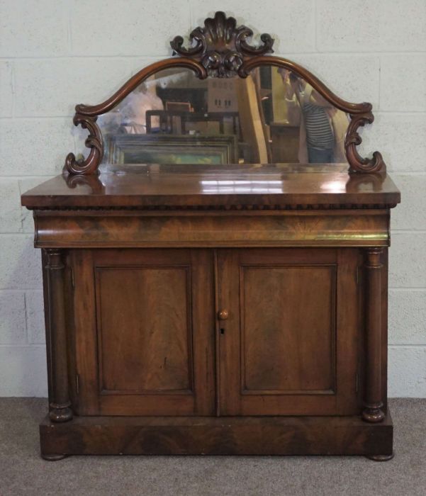 A mid Victorian mahogany chiffonier, circa 1850, with a scrolled mirrored back centred by stiff