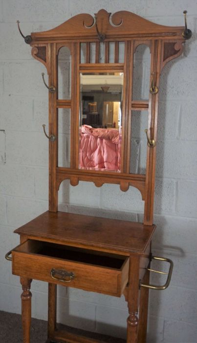 An Edwardian oak hall stand, circa 1910, with a shaped mirror set back with seven hat hooks, over - Image 6 of 8