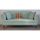 A small Victorian sofa, currently upholstered in jade green, with mahogany turned feet and brass