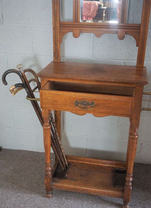 An Edwardian oak hall stand, circa 1910, with a shaped mirror set back with seven hat hooks, over - Image 3 of 8