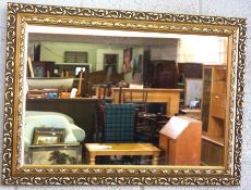 A pressed brass octagonal mirror frame, 20th century; together with a modern gilt framed wall mirror