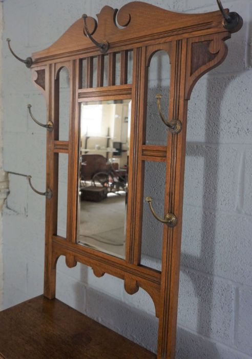 An Edwardian oak hall stand, circa 1910, with a shaped mirror set back with seven hat hooks, over - Image 7 of 8