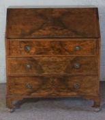 A reproduction George II walnut veneered bureau, with fall front, and three drawers, 107cm high,