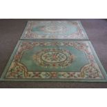 A pair of small modern Aubusson style rugs, with decorative floral borders on a light blue field