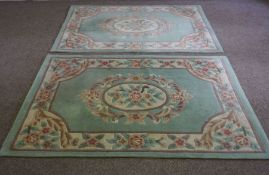 A pair of small modern Aubusson style rugs, with decorative floral borders on a light blue field