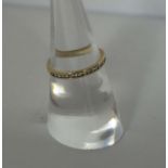 A diamond half hoop eternity ring, with eighteen seed diamonds in a plain hoop 9 carat gold setting,