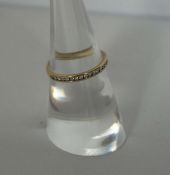 A diamond half hoop eternity ring, with eighteen seed diamonds in a plain hoop 9 carat gold setting,