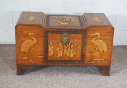 A Chinese camphor chest, 20th century, with carved figures of Immortals, 56cm high, 101cm wide