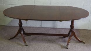 A George III style mahogany D end extending dining table, set on twin pillars, later adapted with