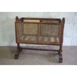 A George IV mahogany framed child’s crib, 19th century, the rectangular caned crib set on twin