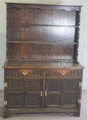 A small oak Jacobean style dresser, 20th century, with two shelves over two drawers and cabinets,