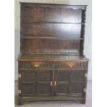 A small oak Jacobean style dresser, 20th century, with two shelves over two drawers and cabinets,