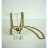 A long multi facet yellow metal chain link necklace, with cabochon garnet set clasp, apparently