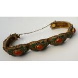 A silver gilt articulated bangle, with amber cabochons and green enamel leaves, early 20th