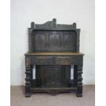 A Carolean oak livery cupboard or dresser, 17th century and later, with a carved triple panelled