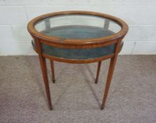 A late Regency oval mahogany vitrine table, 19th century, with a hinged glazed lid and clear