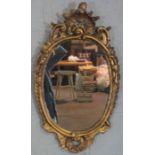 A George II style composition gilt oval wall mirror, 80cm x 43cm; together with a small gilt