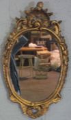 A George II style composition gilt oval wall mirror, 80cm x 43cm; together with a small gilt