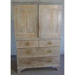 A limed oak linen press, 19th century and later, with two panelled press doors over two short and