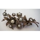 A silver and pearl set Victorian brooch, decorated with flower heads and set with multiple seed