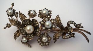 A silver and pearl set Victorian brooch, decorated with flower heads and set with multiple seed