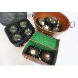 A set of four Edwardian lignum vitae turned lawn bowls, each with an ivory insert plaques numbered 1