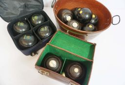 A set of four Edwardian lignum vitae turned lawn bowls, each with an ivory insert plaques numbered 1