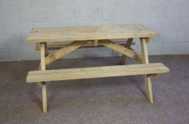 A modern pine picnic table, with bench seats, 73cm high 150cm long, made by Kaimburn of Jedburgh