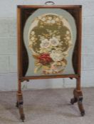 A Victorian mahogany firescreen, circa 1870, with inset floral tapestry and vertical slide, set on