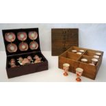 A set of ten Japanese porcelain saké cups, with iron red decoration of figures in a landscape,
