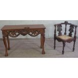 A Victorian style carved hardwood corner chair, with double eagle head carved splats and a caned