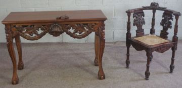 A Victorian style carved hardwood corner chair, with double eagle head carved splats and a caned